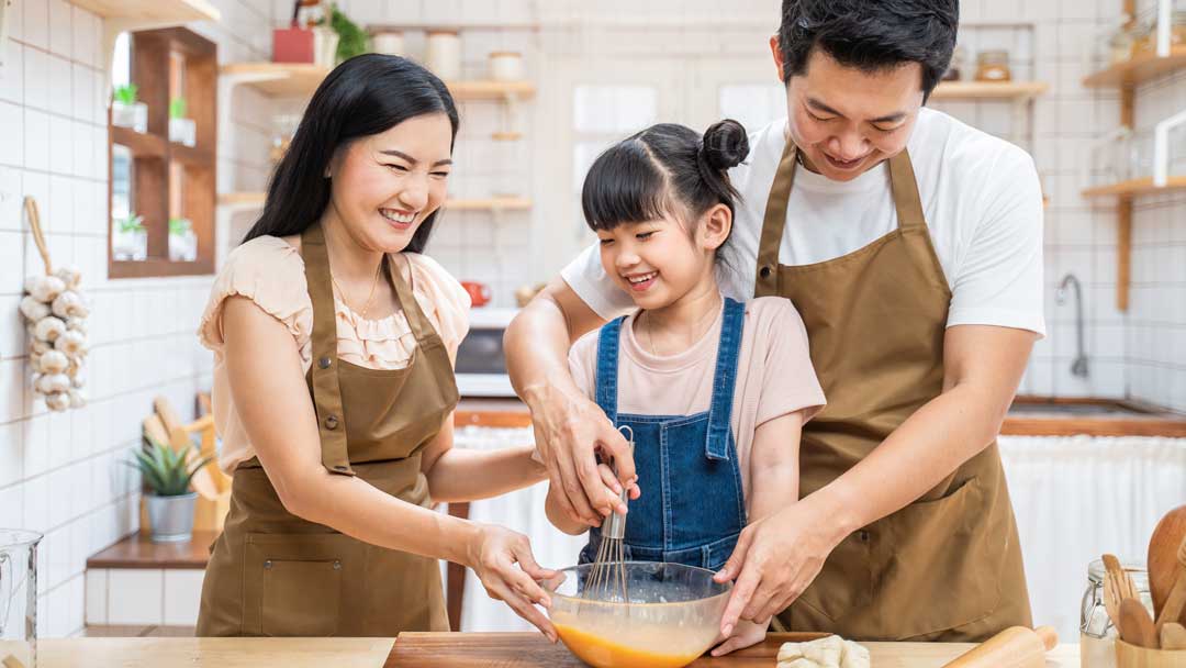 happy asian family baking in kitchen